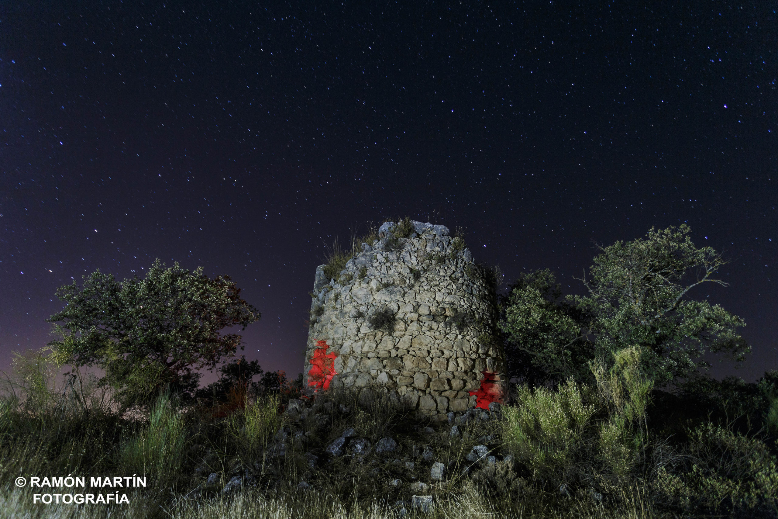 Construcción de piedra iluminada bajo un cielo estrellado